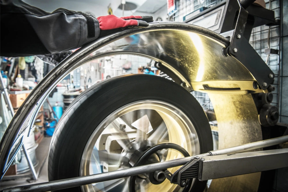 Prostowanie felg na maszynie z wirującą aluminiową felgą pod osłoną zabezpieczającą