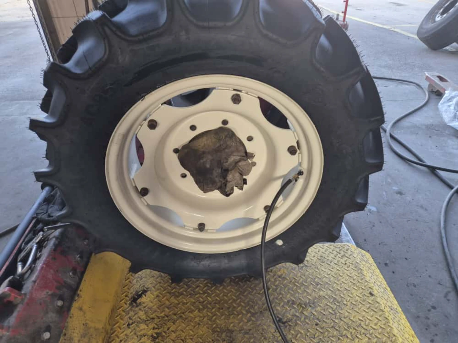 Felga ciągnikowa po lakierowaniu proszkowym umieszczona na stanowisku warsztatowym