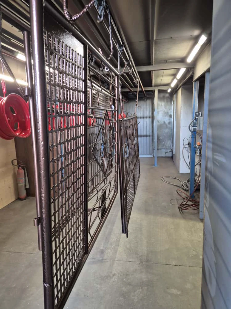 Metalowe panele ogrodzenia kute zawieszone w warsztacie po lakierowaniu proszkowym