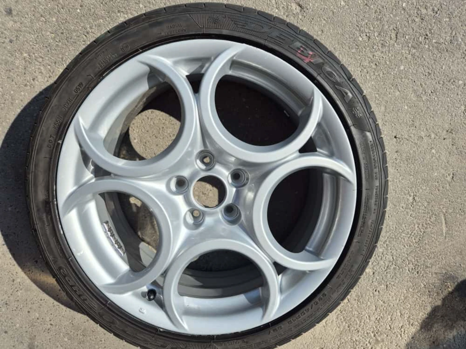 Felga aluminiowa po lakierowaniu proszkowym na tle betonowego podłoża