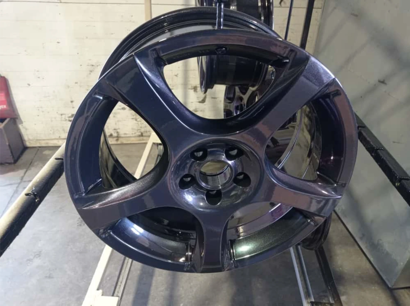 Lakierowanie proszkowe czarnej metalowej felgi samochodowej na stojaku