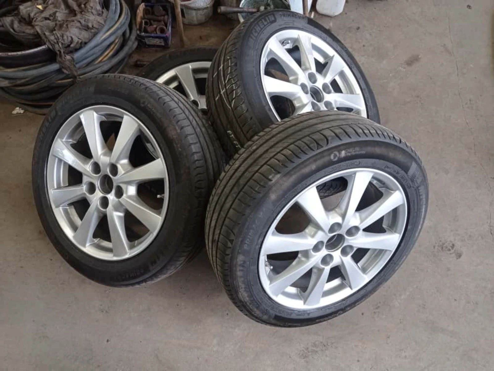 Zestaw czterech srebrnych felg aluminiowych z oponami po lakierowaniu proszkowym