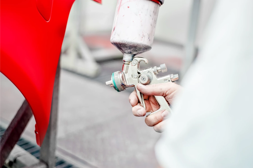 Malowanie proszkowe czerwonego elementu karoserii pistoletem
